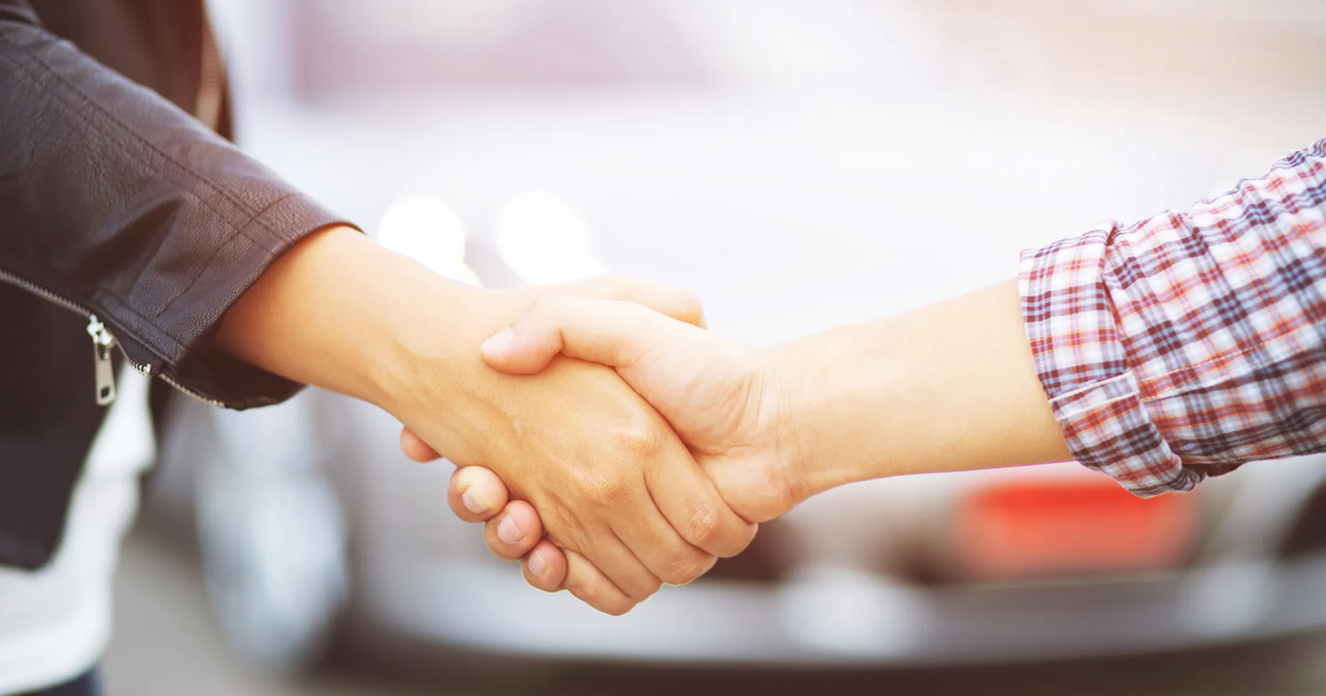 Two people meeting in a public place to complete a sale